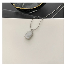 Detail view of silver minimalist necklace featuring a double-sided shell pendant