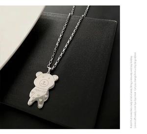Detail view of a silver bear pendant with superstar engraving on a long link chain