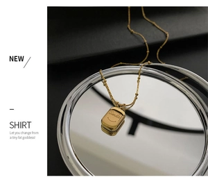 Macro shot of gold-plated smile pendant necklace with engraved lettering on mirror surface