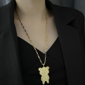 Golden bear necklace with superstar engraving on paperclip chain worn on black suit