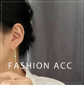 Detailed view of long bamboo style gold earrings on model for an elegant drop effect