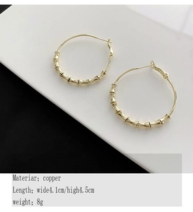 Detailed close-up of golden bamboo textured hoop earrings made of high-quality copper