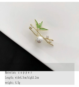 Detailed view of bamboo brooch with green enamel leaves, zircons and a white pearl drop