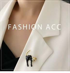Detail of a cute black and white polka dot cat brooch pinned on a white blazer lapel