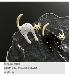 Detailed view of black and white enamel cat brooches with copper size specifications