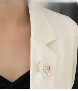 Close-up of cute white cat brooch with black dots on white suit lapel