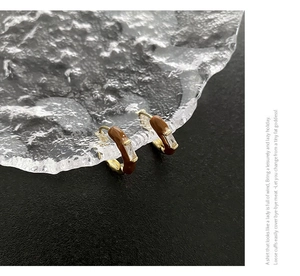 Detailansicht der goldenen C-Ohrringe mit brauner Emaille und Zirkonia-Steinen