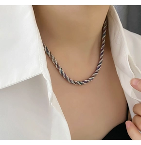 Macro detail of twisted multi-color metallic rope necklace on model collarbone
