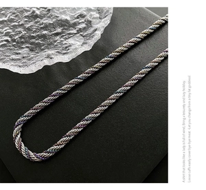 Close-up of silver twist rope necklace with rainbow colored metallic weaving details