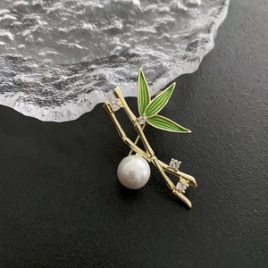 Elegant bamboo brooch with green enamel leaves, cubic zirconia, and a large pearl accent