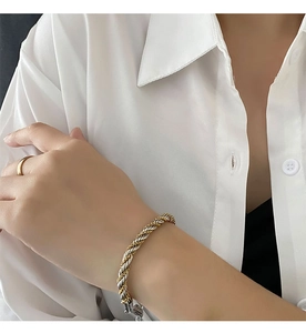 Detailed close-up of a silver and gold braided twist bracelet with secure metal clasp