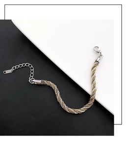 Detail of twisted cable bracelet in gold and silver tones with lobster clasp and tag