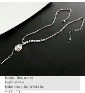 Détail macro du collier en perles de titane avec pendentif coquillage et chaîne câblée