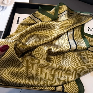 Detailed view of luxury geometric silk-like scarf with olive green maze patterns