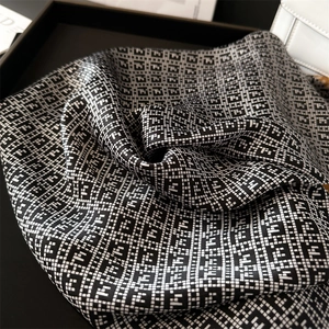 Detail of silk-like scarf featuring black and white geometric F-letter patterns