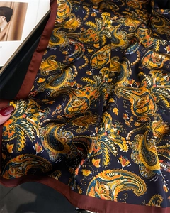 Macro shot of paisley print silk scarf showing smooth texture and vintage ethnic pattern