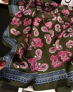 Detailed view of olive green paisley silk scarf with vintage ethnic patterns and satin shine