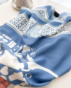 Close-up of elegant blue silk scarf with classic watch and houndstooth print on white table