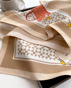 Detail of elegant printed silk scarf featuring houndstooth pattern and handbag motifs