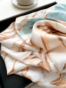 Close-up of abstract floral twill silk scarf with elegant drape and soft texture