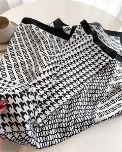 Dettaglio della trama del foulard in seta pied-de-poule con elegante motivo geometrico d