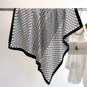 Dettaglio di pied-de-poule e catene su un foulard di seta quadrato bianco e nero