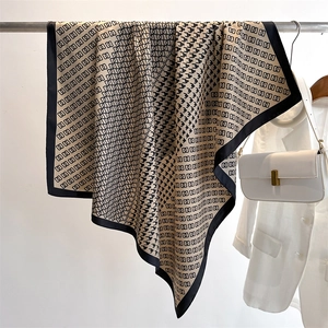 Dettaglio di sciarpa in seta pied-de-poule con motivi a catena e drappeggio elegante