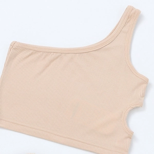 Detailed macro view of beige ribbed knit crop top with one-shoulder and side cutout design