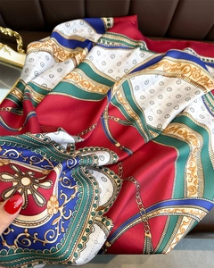 Detail view of the silk scarf with chain pattern and luxurious scrollwork design