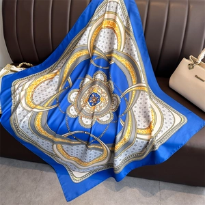 Detailed view of the luxury chain patterns and blue silk fabric texture on the square scarf