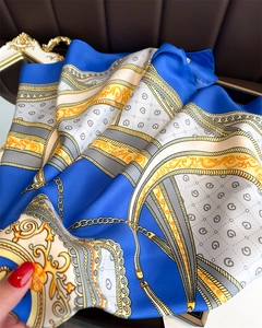 Detailed view of luxury silk scarf showing baroque chain patterns and smooth fabric texture