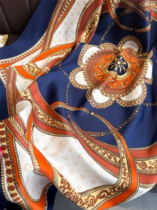 Close-up of silk scarf showing detailed baroque flower patterns and chain design texture