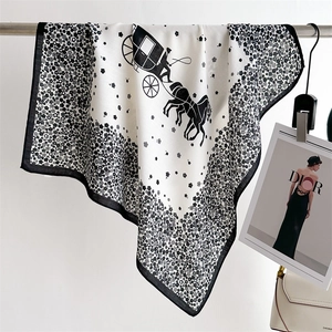 Détail du motif floral et carrosse sur un foulard carré en soie noir et blanc