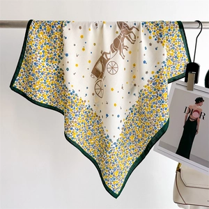 Détail d'un foulard carré fleuri avec motif de calèche et bordure verte en soie satinée