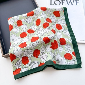 Detailed view of square silk scarf with floral tulip patterns and dark green hemmed edges