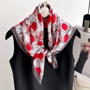 Detailed view of silk square scarf featuring elegant red tulip prints and grey borders