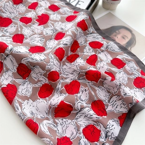 Detailed close-up of a French floral silk scarf featuring elegant red and white tulip patterns