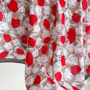 Detailed texture of rose silk scarf with premium herringbone pattern and floral print
