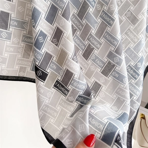 Close-up of geometric printed silk scarf with fashion letters and premium texture