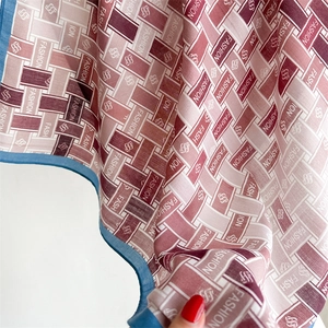 Detail of square silk scarf showing blue rolled hem and fashion pattern texture