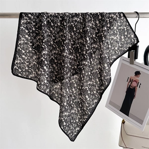 Detail of floral chiffon scarf featuring delicate black edges and sheer fabric texture