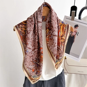 Elegant brown paisley silk scarf styled on a hanger with fashion accessories
