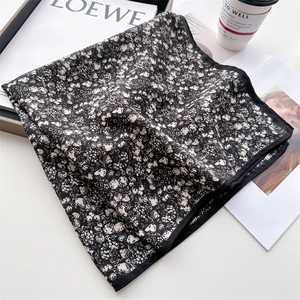Elegant black floral square scarf with delicate white print on marble background