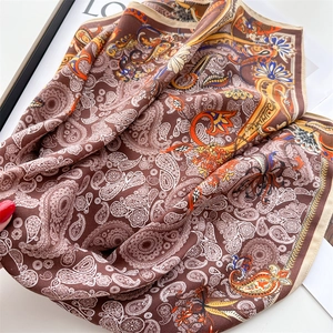 Close-up of paisley pattern silk scarf with vibrant floral details on a fashion magazine
