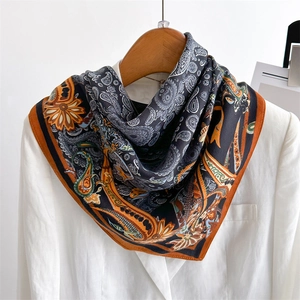 Luxurious paisley silk scarf with herringbone pattern draped on a white blazer coat