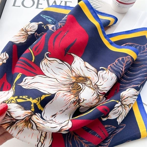 Detail of blue silk scarf featuring white lily prints and red foliage texture