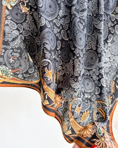 Macro detail of silk-like paisley scarf fabric with intricate vintage floral patterns