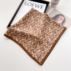 Detailed shot of a floral square silk scarf styled with a coffee cup and tray