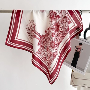 Detail of vintage floral silk scarf in burgundy and beige hanging in a lifestyle setting