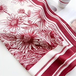 Detailed view of floral pattern silk scarf with daisy sketches and woven texture border